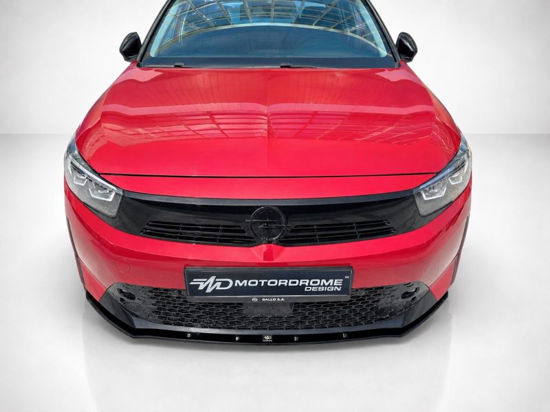 K163-006_5jpg - OPSHOLDERS Front view of a red car showing its grille, headlights, and Opel emblem in a showroom setting (high gloss finish).