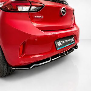 Red Opel Corsa rear view with visible Corsa badge and chrome emblem, showing taillight and customized Motordrome Design license plate frame