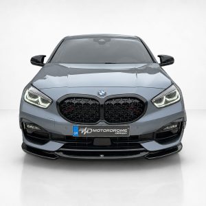Front view of a gray BMW facing the camera, showing distinctive kidney grille and LED headlights in a studio setting with a white background.