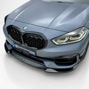 Front view of a blue BMW with kidney grille, emblem, and illuminated angular headlights.