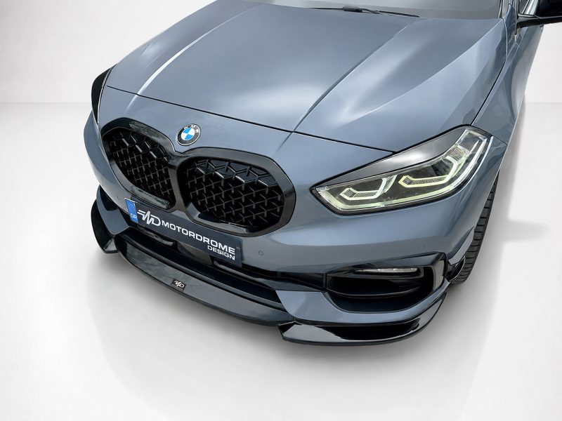 Front view of a blue BMW with kidney grille, emblem, and illuminated angular headlights.