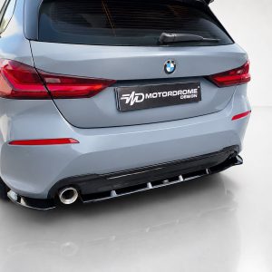 Rear view of a light-blue BMW SUV, showing the MotorDrome Design license plate and red taillights