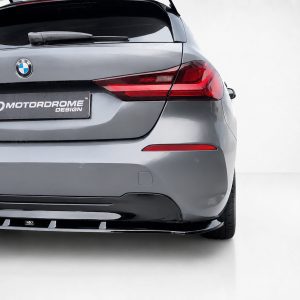 Rear view of a gray BMW hatchback with a Motordrome Design license plate and red taillights