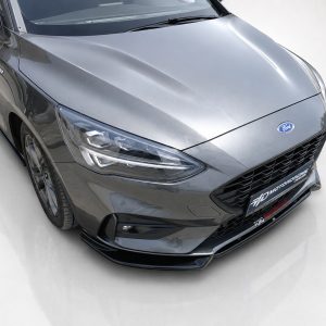Front-angle view of a gray Ford car showing its hood, headlight, and honeycomb grille.