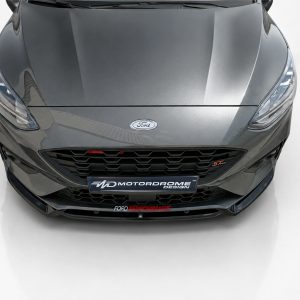 Front view of a gray Ford performance car with a bold honeycomb grille and sleek headlights.