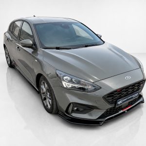 Gray Ford sedan shown in a front-left three-quarter view, highlighting the grille, headlights, and sleek body lines.