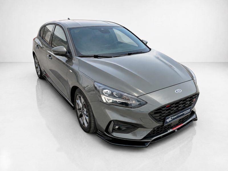 Gray Ford sedan shown in a front-left three-quarter view, highlighting the grille, headlights, and sleek body lines.