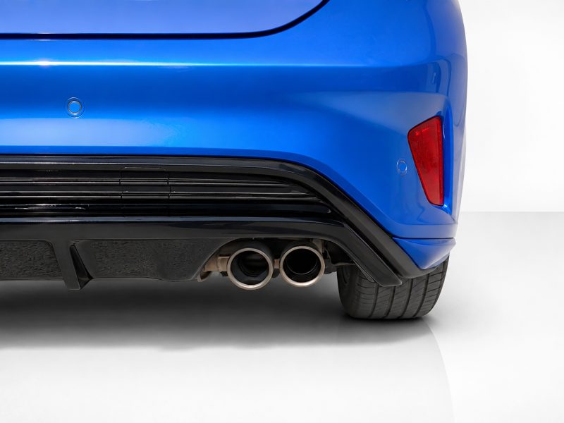 Blue car rear: bumper, dual exhaust pipes, and a red tail light visible on the right side.