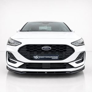Front view of a white Ford sedan with a black honeycomb grille and the MD MotorDrome Design plate in the center. (informative)