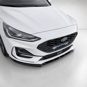 Front end of a white Ford sedan with a black honeycomb grille and prominent headlight details, shown in a studio setting to highlight the car’s design features and front bumper.