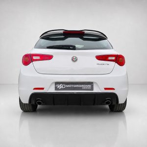 Rear view of a white Alfa Romeo Giulietta hatchback with red taillights and dual exhausts in a studio backdrop
