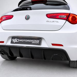 Rear view of a white Alfa Romeo Giulietta with red taillights and a black diffuser feature, shows a motorsport design plate.