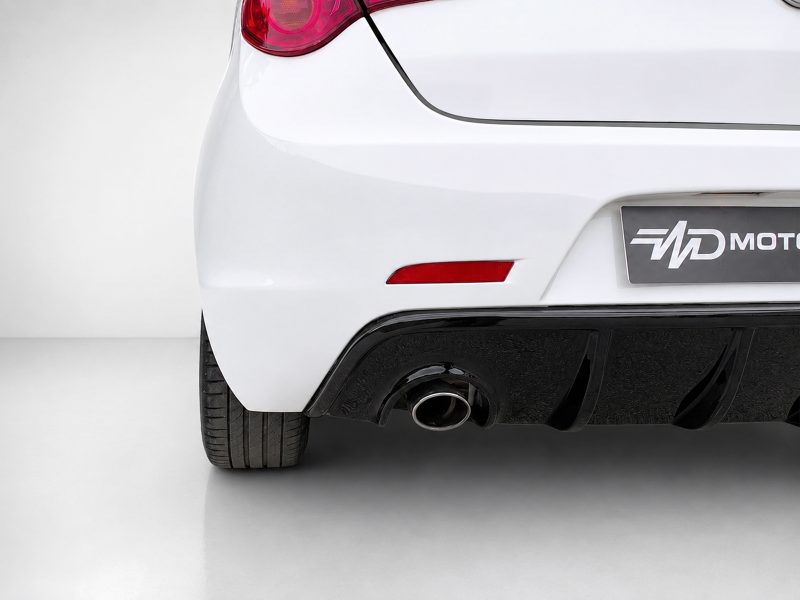 Rear view of a white car showing the exhaust tip, lower bumper, and red taillight.
