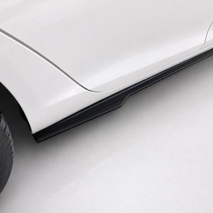 Close-up of a silver car's side showing a black running board along the lower edge.