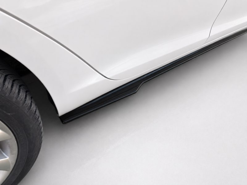 Close-up of a silver car's side showing a black running board along the lower edge.