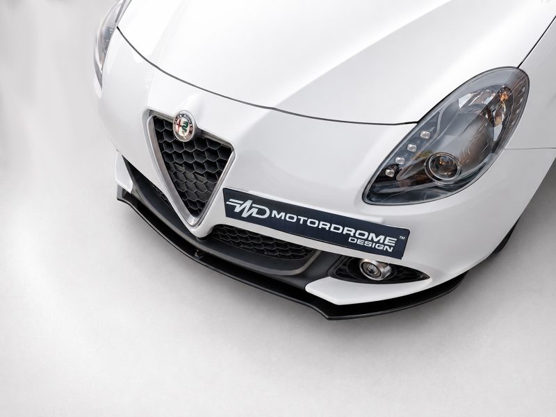 K166-004_3jpg - OPSHOLDERS White sports car front view with honeycomb grille, brand badge, and a Motordrome Design plate on the bumper.