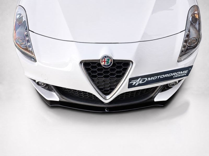 K166-004_4jpg - OPSHOLDERS Front view of a white Alfa Romeo with a honeycomb front grille, emblem at center, and a black bumper with an 'MD MOTORDROME DESIGN' sticker on the right side