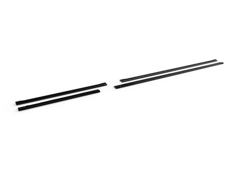 Two black roof rack crossbars laid out on a white background, separated into two pairs for a car roof installation