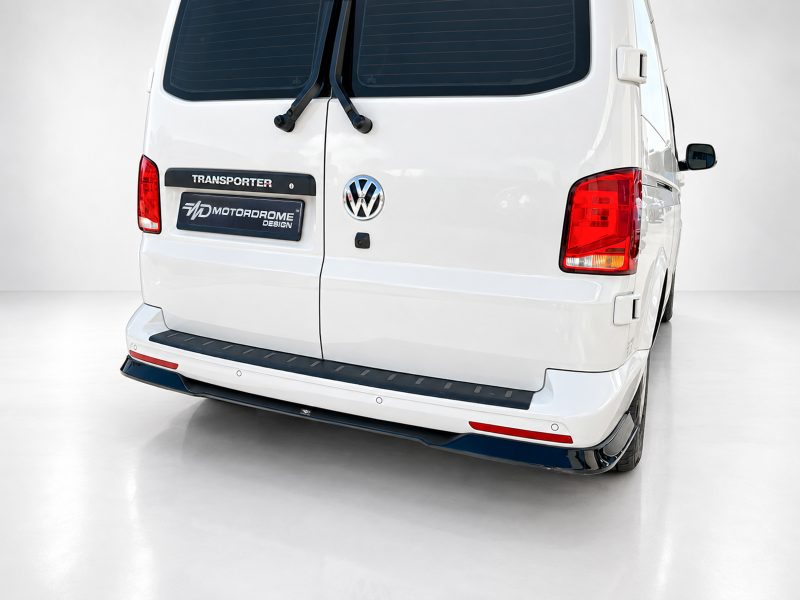 Rear view of a white Volkswagen Transporter van, showing the VW emblem, rear doors, and vertical wipers in a clean studio setting.