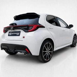 White compact hatchback viewed from the rear-right, showing a black roof spoiler, taillights, and 'HYBRID' badge with a glossy bumper and dual exhausts.
