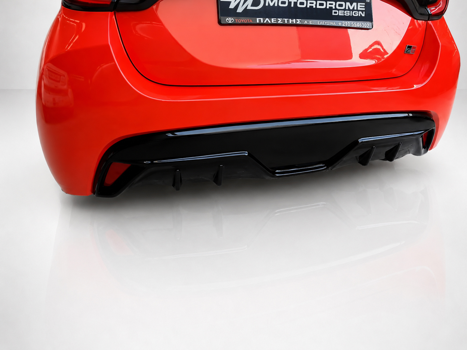 K169-003_2jpg - OPSHOLDERS Red car rear end with a black diffuser and glossy bumper; license plate area visible above the diffuser.