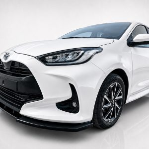 White Toyota sedan shown from a front-left angle with the grille, headlight cluster, and alloy wheels visible behind a glossy finish.