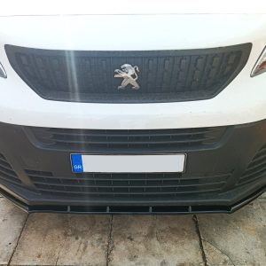Close-up front view of a white Peugeot vehicle showing the black grille with a silver lion emblem and a European license plate partially visible.