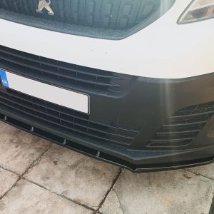 Front view of a white vehicle showing the grille with a Peugeot emblem and a blue GR license plate area at the lower left of the bumper.