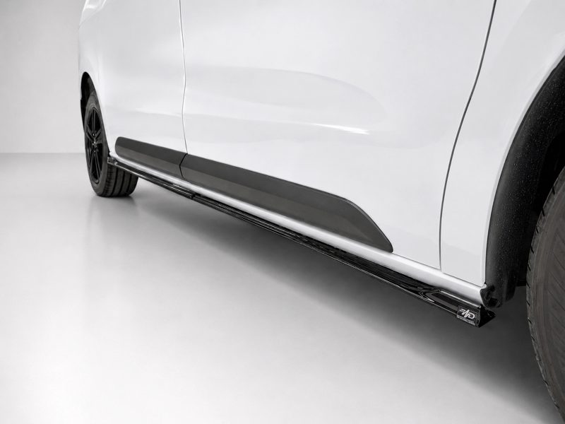 White car side with a black running board/side step visible below the doors.