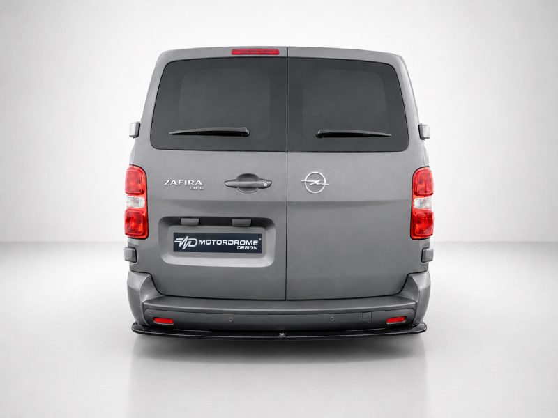 Rear view of a gray Opel van (Zafira Life) with rear doors closed and a Motordrome Design plate visible on the bumper area.