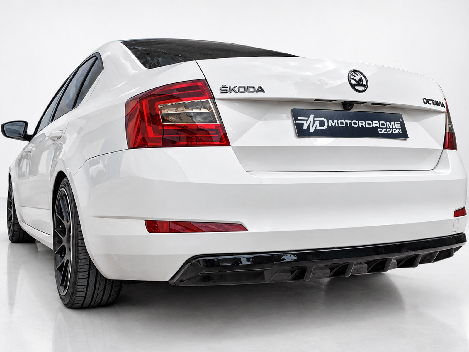 K171-001_1jpg - OPSHOLDERS Rear view of a white Skoda Octavia with a customized plate reading 'MOTORDROME DESIGN' and dark tinted rear window