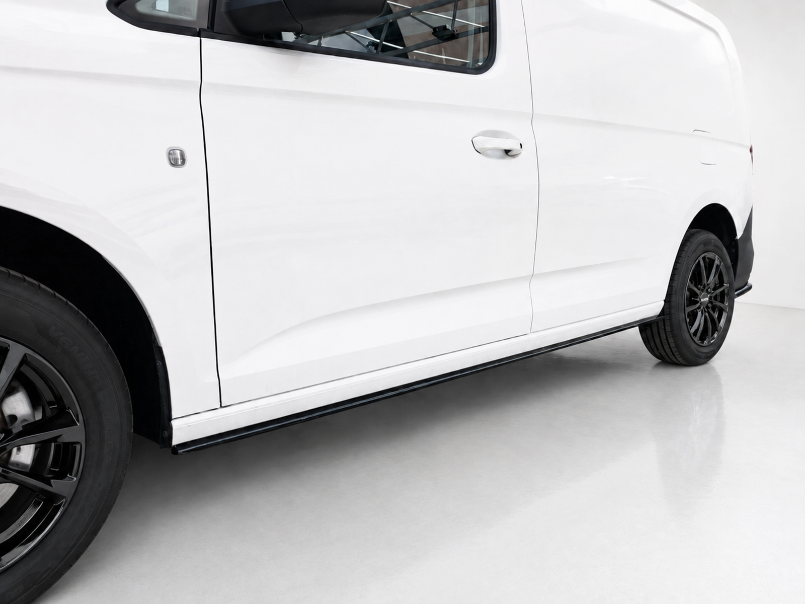 K172-003_2jpg - OPSHOLDERS White van shown from the side with black alloy wheels and a running board along the bottom edge.