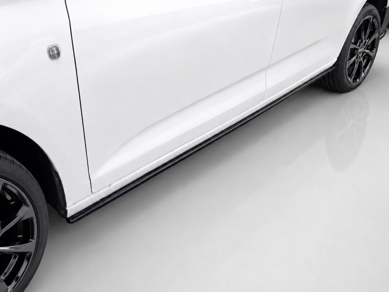 K172-003_3jpg - OPSHOLDERS Close-up of a white car's lower side with a black running board and alloy wheels.