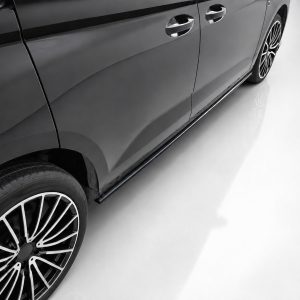 K172-005_3jpg - OPSHOLDERS Side view of a sleek black car showing its glossy door panels and large alloy wheel on a white floor surface