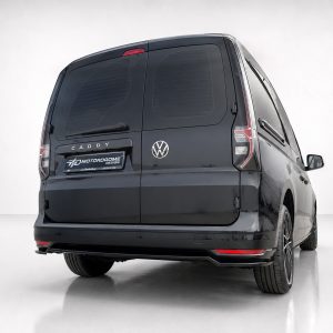 Rear view of a black VW Caddy van with a Motordrome Design plate on the bumper and tinted rear doors, in a studio setting.