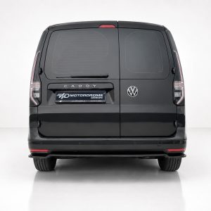 Rear view of a black VW Caddy van with split rear doors, VW badge, and a branded MD Motordrome Design license plate on the tailgate.