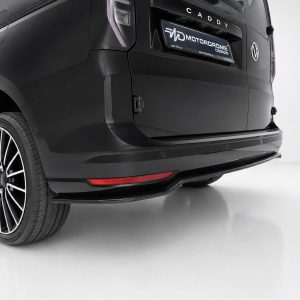 Rear of a black van showing a stylish alloy wheel, taillight, and red rear reflector on the bumper.