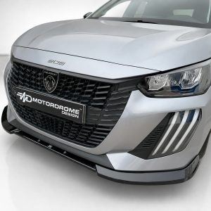 Front-angle view of a silver Peugeot car showing its large grille, badge, and LED headlight cluster with a MotorDrome Design plate on the bumper.