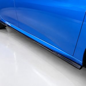 Blue car parked indoors, side view showing chrome lower body molding and rear wheel.