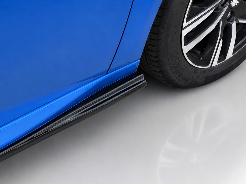 Close-up of a blue car's side skirt and alloy wheel with tire