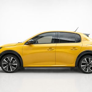 Yellow hatchback car shown in a side profile in a studio setting with black trim and large alloy wheels.