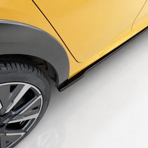Close-up of a yellow car showing the front wheel with a black fender flare and a lower black side step along the body.