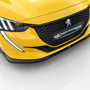 Front view of a bright yellow Peugeot 208, showing the grille, sharp headlight with LED strip, and a black plate reading 'Motordrome Design'