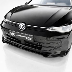 K174-002_3jpg - OPSHOLDERS Front view of a glossy black Volkswagen in a studio, displaying the logo and a Motordrome Design license plate on the bumper.