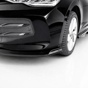 K174-002_4jpg - OPSHOLDERS Close-up of a glossy black car front with bumper and headlight, and the left front wheel visible on a white background.