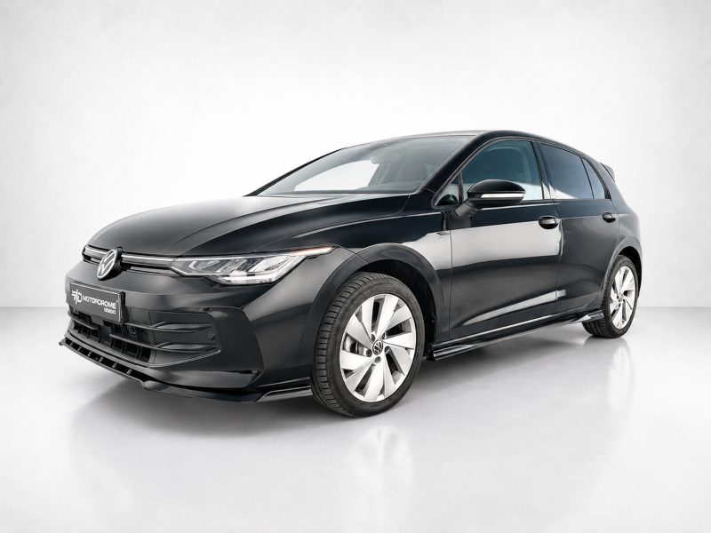 Front three-quarter view of a glossy black Volkswagen sedan in a bright studio setting, showcasing sleek lines and alloy wheels.