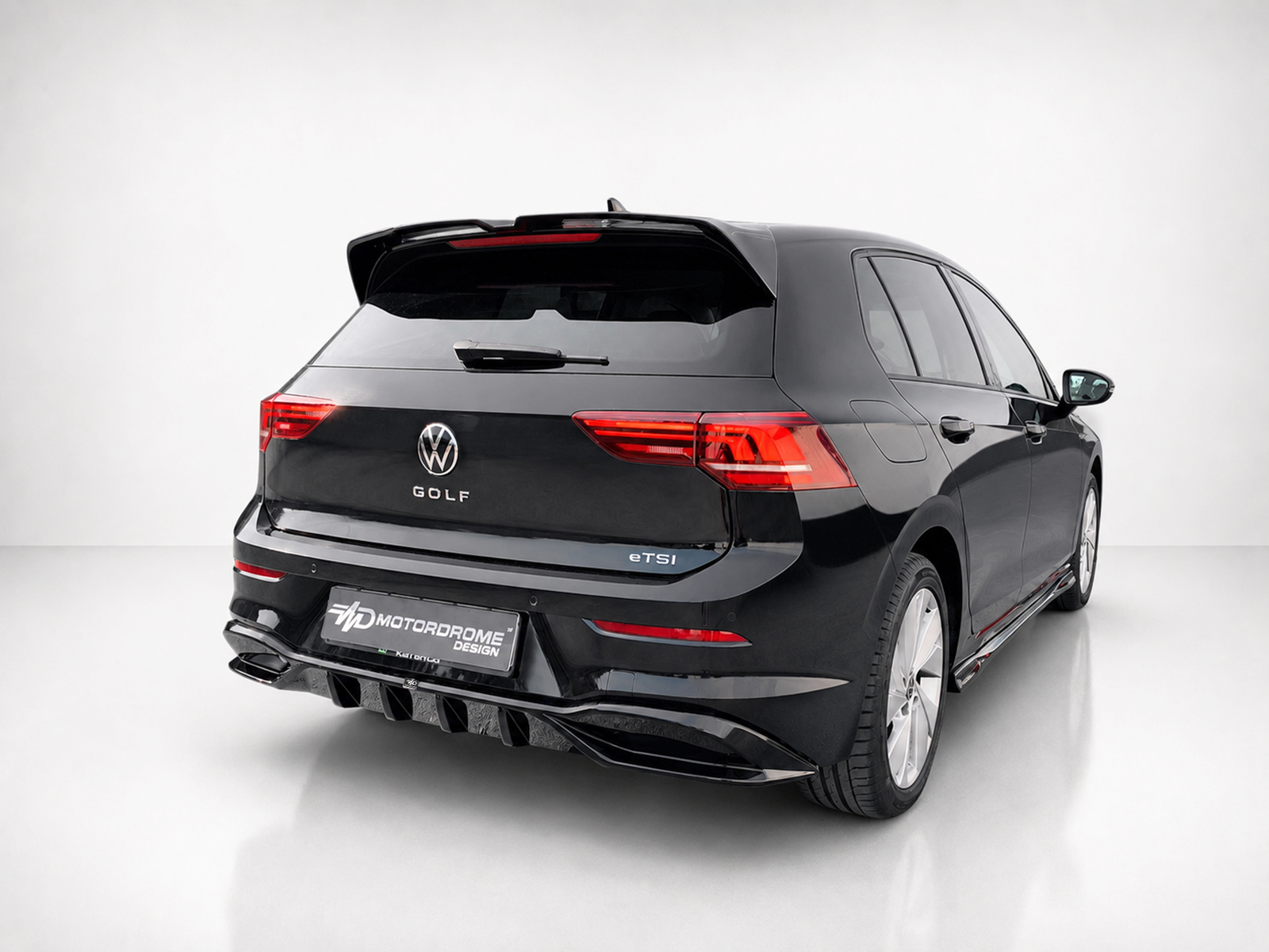 K174-004_2jpg - OPSHOLDERS Black Volkswagen Golf eTSI wagon viewed from rear-left in a studio; badge reads GOLF and eTSI on the tail. Plate shows Motordrome Design.