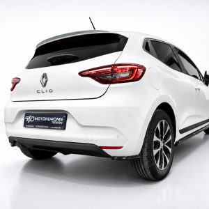 Rear three-quarter view of a white Renault Clio in a studio, showing distinctive red taillights and Renault emblem