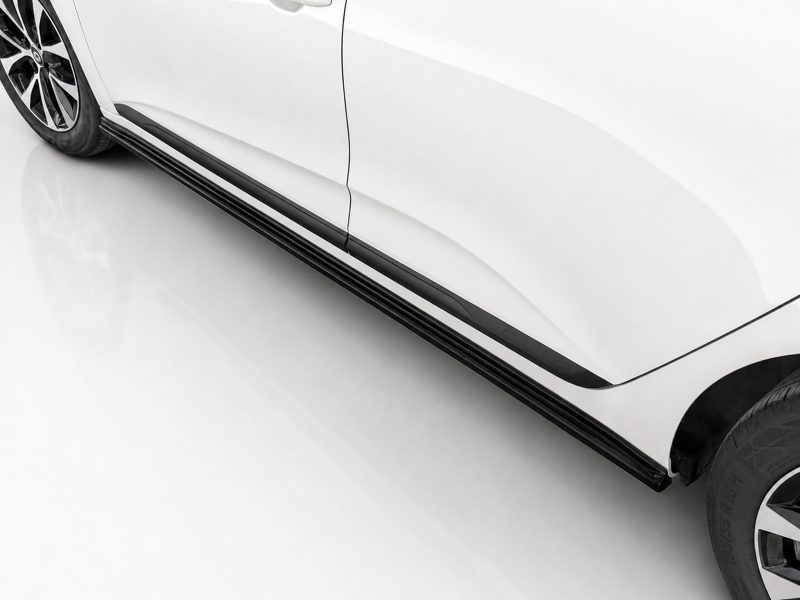 White SUV with black side running board along the lower body, wheel visible on the left side and tire on the right edge.