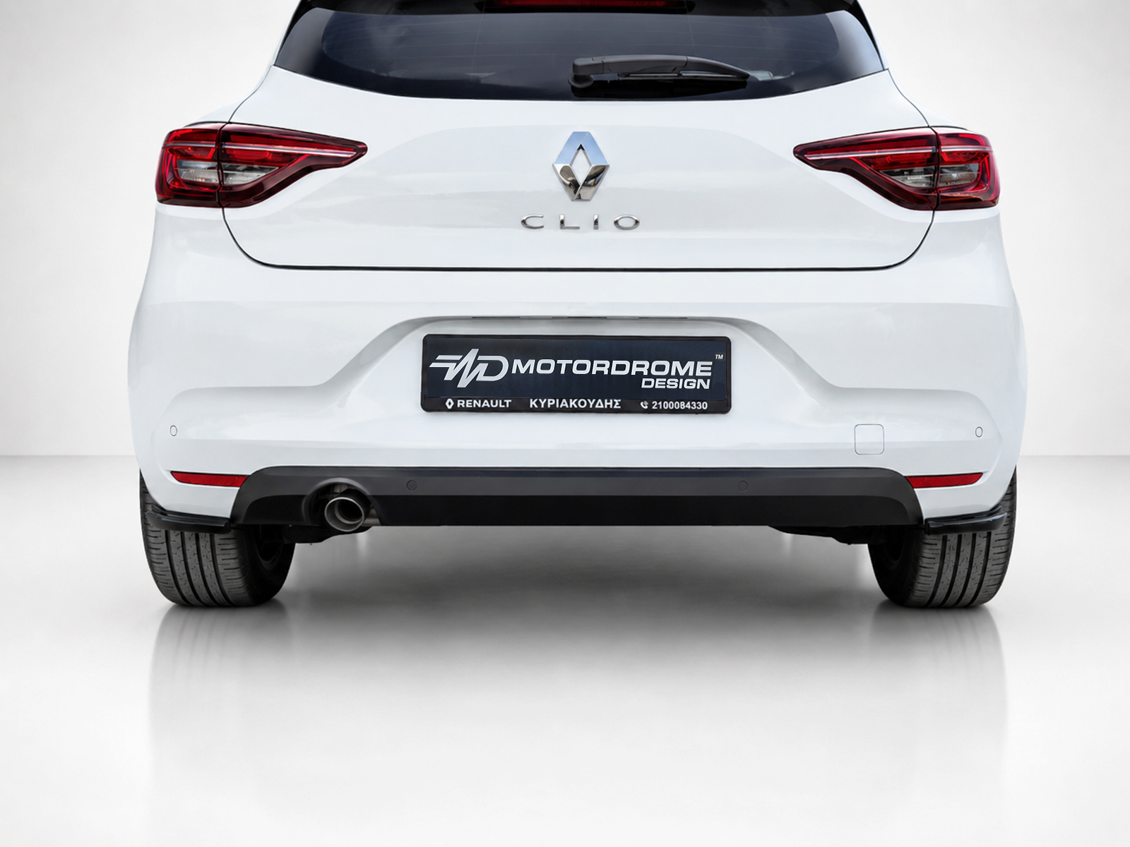 K175-004_2jpg - OPSHOLDERS Rear view of a white Renault Clio showing the hatch with red taillights and a Motordrome Design license plate area